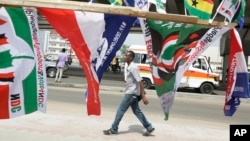 A man walk past election campaign flags on a street in Accra, Ghana, Dec. 6, 2016. Polls will open Dec. 7 at 0700 UTC.