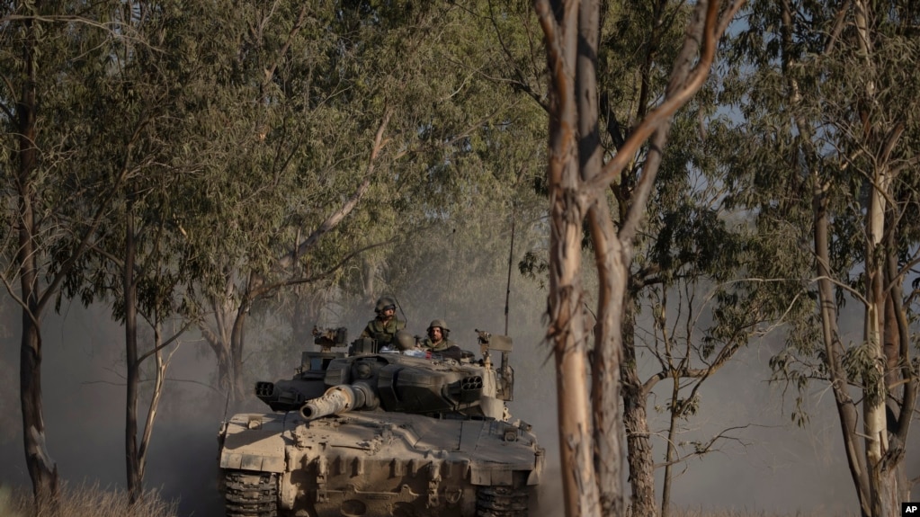 Soldados israelíes se mueven encima de un tanque cerca de la frontera entre Israel y Gaza, visto desde el sur de Israel, el sábado 29 de junio de 2024. (Foto AP/Leo Correa)
