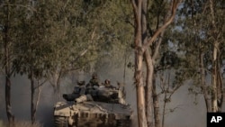 Soldados israelíes se mueven encima de un tanque cerca de la frontera entre Israel y Gaza, visto desde el sur de Israel, el sábado 29 de junio de 2024. (Foto AP/Leo Correa)