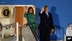 El presidente de EE.UU. Donald Trump y la primera dama Melania Trump, saludan desde su avión Air Force One a su llegada a Varsovia, la capital de Polonia, para una escala corta de camino a la Cumbre del G-20 en Alemania.