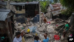 아이티에서 7.2 강진이 발생한 가운데 15일 한 가족이 지진으로 무너진 집 앞에서 아침식사를 하고 있다. 
