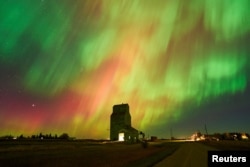 FILE - The aurora borealis, also known as the northern lights, light up the sky over an old grain elevator in Brant, Alberta, Canada October 7, 2024. (REUTERS/Todd Korol)