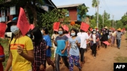 This handout photo taken and released by Dawei Watch on May 5, 2021, shows protesters holding signs during a demonstration against the military coup in Dawei, Myanmar.