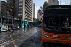 Buses that were set on fire by demonstrators stand on a street in Santiago, Chile, Oct. 19, 2019. President Sebastian Pinera Friday night announced a state of emergency and deployed the armed forces into the streets.