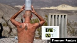 FILE: In a previous heatwave, a man holds a water container atop his head in Death Valley, California, on August 19, 2020.