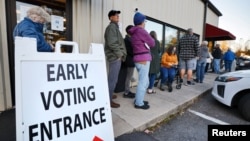 Voters wait to cast their ballot on the first day of early in-person voting in one of the mountainous regions badly affected by Hurricane Helene, in Marion, North Carolina, Oct. 17, 2024.