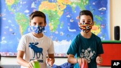 FILE - Nine-year-old boys Tom, left, and Patrizio wear face masks to protect against the coronavirus at the Lenneberg Primary and Secondary School in Mainz, Germany, Aug. 17, 2020. 