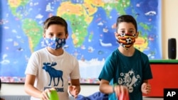 FILE - Nine-year-old boys Tom, left, and Patrizio wear face masks to protect against the coronavirus at the Lenneberg Primary and Secondary School in Mainz, Germany, Aug. 17, 2020. 