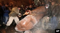 Para demonstran oposisi Ukraina merusak monumen Vladimir Lenin di Kiev, Ukraina hari Minggu (8/12). 