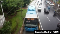 Bus Transjakarta yang beroperasi di sekitar Gereja Katedral Jakarta pada Hari Natal, Rabu, 25 Desember 2019. (Foto: Sasmito Madrim/VOA)