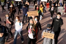 Demonstrators march in San Francisco on Sunday, May 31, 2020, protesting the death of George Floyd, who died after being restrained by Minneapolis police officers on May 25.