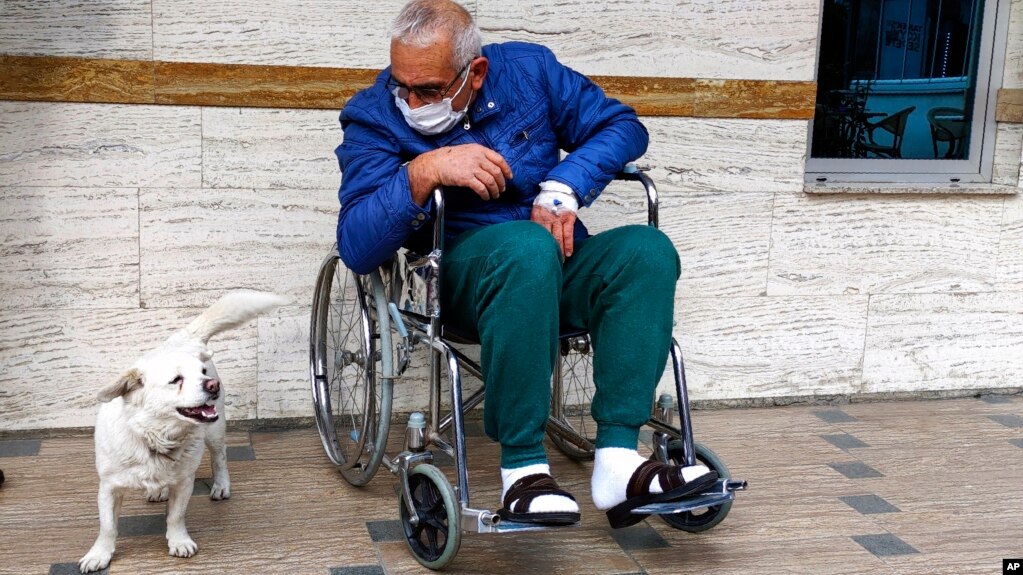 Cemal Senturk, owner of Boncuk, outside of a medical care facility in the Black Sea city of Trabzon, Turkey, Wednesday, Jan. 20, 2021. Boncuk has spent five days waiting in front of the hospital where her sick owner was receiving treatment. (DHA via AP)