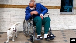 Cemal Senturk, owner of Boncuk, outside of a medical care facility in the Black Sea city of Trabzon, Turkey, Wednesday, Jan. 20, 2021. Boncuk has spent five days waiting in front of the hospital where her sick owner was receiving treatment. (DHA via AP)