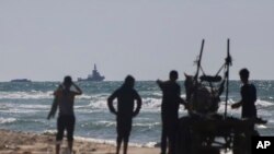 FILE—A ship belonging to the Open Arms aid group approaches the shores of Gaza towing a barge with 200 tons of humanitarian aid on Friday, March 15, 2024. The ship set sail Tuesday from Cyprus to inaugurate a sea route to get desperately needed aid into the war-wracked enclave.