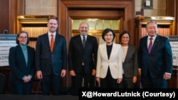 照片说明：美国商务部长卢特尼克(左三)、美国贸易代表格里尔(左二)和美国在台协会华盛顿总部执行理事蓝莺(Ingrid D. Larson，左一)与台湾行政院副院长郑丽君(右三)、台湾行政院政务委员杨珍妮(右二)和台湾驻美代表处代表俞大㵢(右一)。