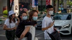 Chinese family wearing face masks walk in a pedestrian crossing in Bangkok, Thailand, Wednesday, Jan. 29, 2020. Tourism Council of Thailand said Tuesday that new coronavirus outbreak estimated to cost 50 billion Bhat (1,613,892 US Dollars) in lost…