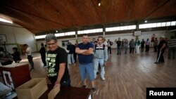People stand in line to cast their votes at a polling station, in Montevideo, Uruguay, Oct. 27, 2019.