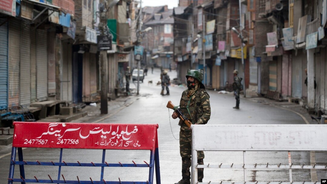 Tentara Paramiliter India berjaga di jalan sepi saat jam malam di Srinagar, Kashmir yang dikuasai India, Kamis, 8 Agustus 2019.