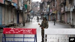 Tentara Paramiliter India berjaga di jalan sepi saat jam malam di Srinagar, Kashmir yang dikuasai India, Kamis, 8 Agustus 2019.