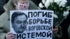 A woman holds a placard with a portrait of Sergei Magnitsky during an unauthorised rally in central Moscow December 15, 2012. 