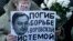 A woman holds a placard with a portrait of Sergei Magnitsky during an unauthorised rally in central Moscow December 15, 2012. 