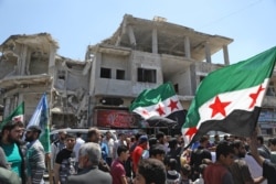 FILE - Syrian demonstrators rally in the town of Binnish in Syria's northwestern Idlib province, May 1, 2020, to condemn a reported attack by the Hayat Tahrir al-Sham group on a protest the previous day.
