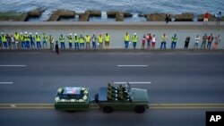 People line the Malecon seaside boulevard as they watch the motorcade transporting the remains of Cuban leader Fidel Castro in Havana, Cuba, Nov. 30, 2016. 