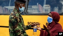 A Kenyan police officer prevents a resident from leaving the Eastleigh area of Nairobi, Kenya, May 7, 2020. 