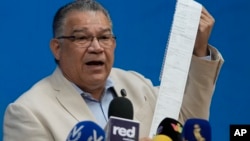 El ex candidato presidencial Enrique Márquez, del Partido Centrados, sostiene un acta de recuento de resultados electorales en Caracas, Venezuela, el miércoles 14 de agosto de 2024. (Foto AP/Ariana Cubillos)