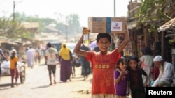 FILE - A Rohingya boy carries a relief supply package with the USAID logo on it, at a refugee camp in Cox's Bazar, Bangladesh, Feb. 11, 2025.