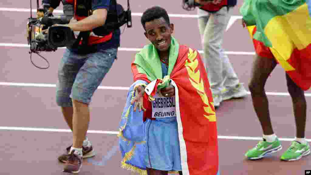Ghirmay Ghebreslassie de l'Érythrée communie avec la foule après avoir remporté la médaille d'or au marathon masculin des championnats du monde d'athlétisme au Nid d'oiseau à Pékin, 22 août 2015