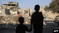 Children stare at the destruction following an Israeli strike in the Nuseirat refugee camp in the central Gaza Strip on Nov. 7, 2024.