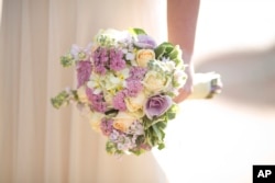 In this Dec. 14, 2017 photo, a bride holds a bouquet during her wedding in Ein Hemed, Israel. (AP Photo/Ariel Schalit, File)