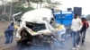 FILE - People at the scene of an accident between a university bus and a passenger shuttle at Naivasha area, along the Nairobi - Nakuru Highway, Kenya, Thursday March 30, 2023.