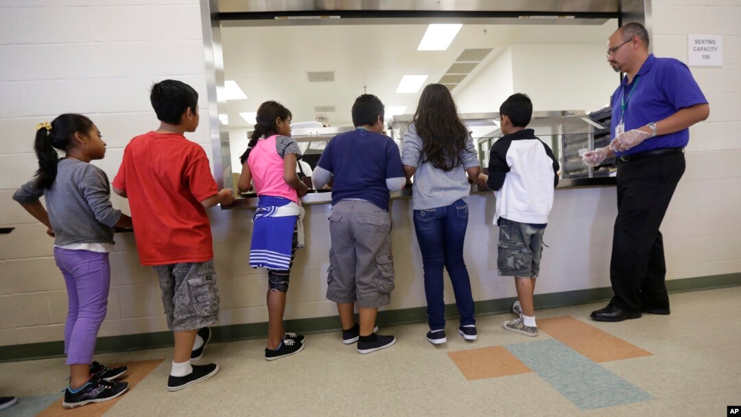 Anak-anak imigran mengantre makanan di kafetaria Pusat Penampungan Karnes County, di Karnes City, Texas, 10 September 2014.