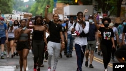 FILE - Demonstrators march near the White House as they protest police brutality and racism June 10, 2020, in Washington, DC. 