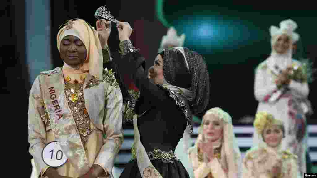 La Nigeriane Obabiyi Aishah Ajibola en train d'être couronnée par sa prédecesseuse Miss Muslimah 2012, Nina Septiani d'Indonesie (D), au cours de Miss Muslimah 2013 à Jakarta le 18 septembre 2013.