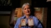 FILE - Peg Reif holds pictures of her children adopted from South Korea in the 1980s in her home Dec. 17, 2024, in Platteville, Wis. 