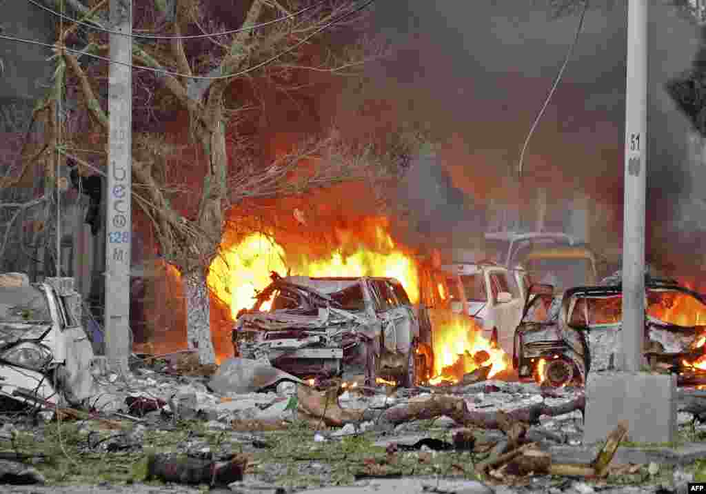 Wrecked cars burn at the scene of a terror attack at the Ambassador Hotel in Mogadishu, Somalia, after a car bomb exploded, killing several people.