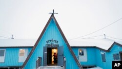 Seorang wanita tiba di Gereja Santo Petrus Nelayan, 19 Januari 2020, di Toksook Bay, Alaska. (Foto: AP)