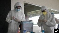 Trabajadores de la salud se preparan para tomar muestras de hisopos nasales para detectar COVID-19 en Caracas, Venezuela. Septiembre 19, 2020.