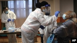 Mary Mack, right, a resident of senior housing, is tested for COVID-19 in Paterson, New Jersey, May 8, 2020.