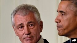 Menteri Pertahanan Chuck Hagel, kiri, mendengarkan Presiden Barack Obama, kanan, menjelaskan pengunduran diri Hagel dalam sebuah acara di Gedung Putih, Washington, 24 November 2014. 