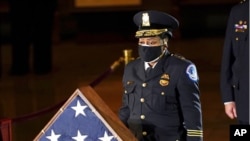 In this Feb. 2, 2021 file photo, acting U.S. Capitol Police Chief Yogananda Pittman pays respects to U.S. Capitol Police officer Brian Sicknick in the Capitol Rotunda in Washington.