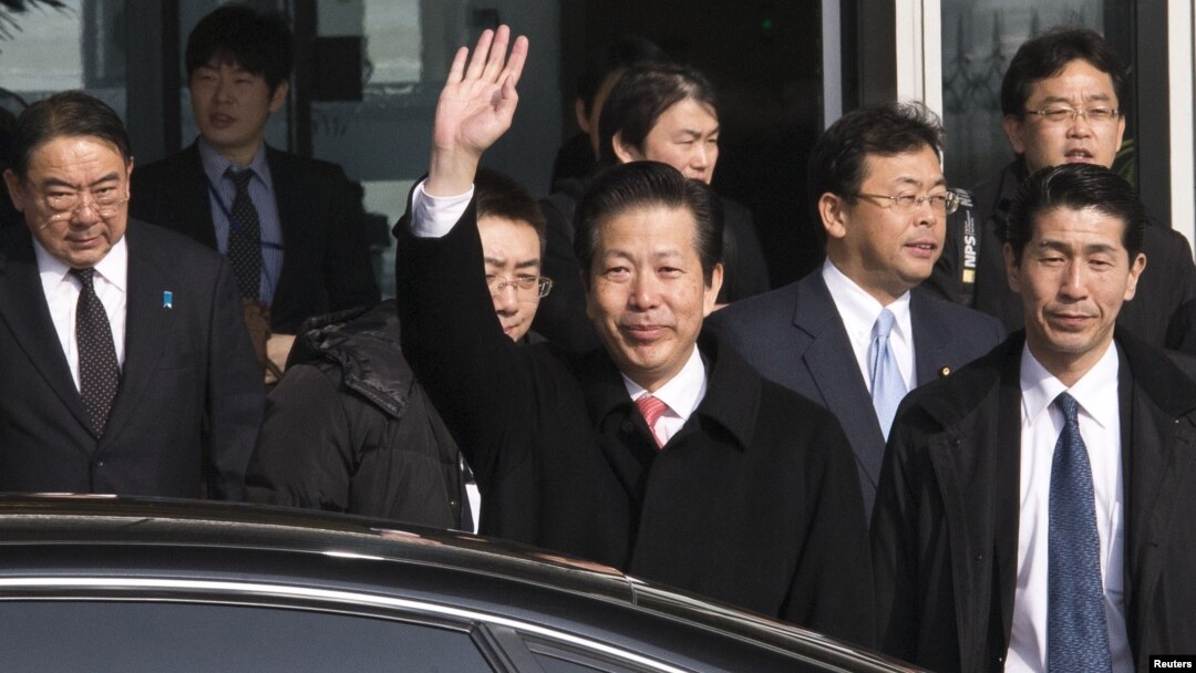 Utusan Jepang, Natsuo Yamaguchi (tengah) melambai saat tiba di bandara internasional di Beijing hari Selasa (22/1). 