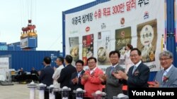 29일 오후 한국 군산항에서 열린 삼계탕 중국 첫 수출 기념식에서 이동필 농림축산식품부 장관과 송하진 전북도시부 등의 축하 속에 수출용 삼계탕 컨테이너가 선적되고 있다.