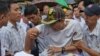 FILE - Having your arm twisted, physically, can hurt. Supporters of nationalist Buddhist monks twist an arm of a youth who allegedly mocked a speaker during a protest rally in Yangon, Myanmar, Dec. 29 2015.
