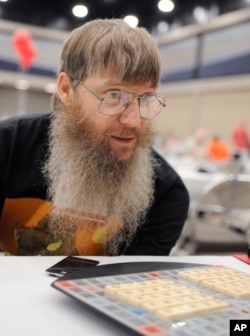 FILE - Tournament favorite and five-time English-language scrabble world champion Nigel Richards looks across the board before the start of his final round, Aug. 13, 2014, at the National Scrabble Championships in Buffalo, NY.