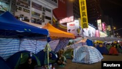 A large banner reading "We want universal suffrage" hung by pro-democracy protesters, is seen on a street light at a main street which they occupied, at Mongkok shopping district in Hong Kong, November 10, 2014.
