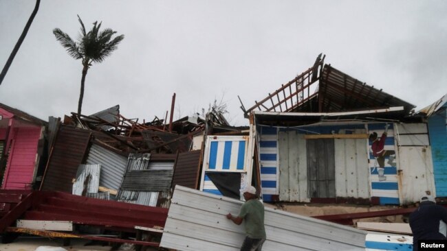 El huracán Fiona azota República Dominicana tras golpear Puerto Rico 4 Un hombre lleva un pedazo de escombros después del huracán Fiona en la costa de Punta Cana, República Dominicana, 19 de septiembre de 2022. REUTERS/Ricardo Rojas